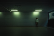 man in gray jacket standing on gray floor tiles