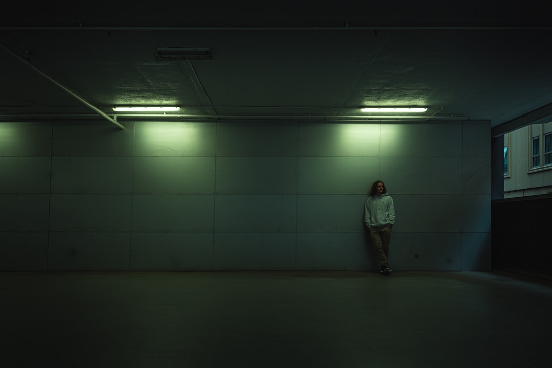 man in gray jacket standing on gray floor tiles,