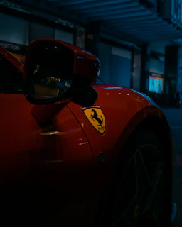 Close-up shot of a sleek matte black Mustang GT with glowing red brake calipers parked on an open highway at dusk.