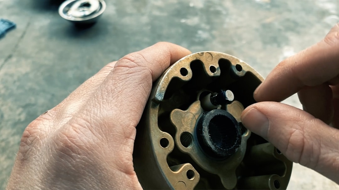 person holding round brown metal tool