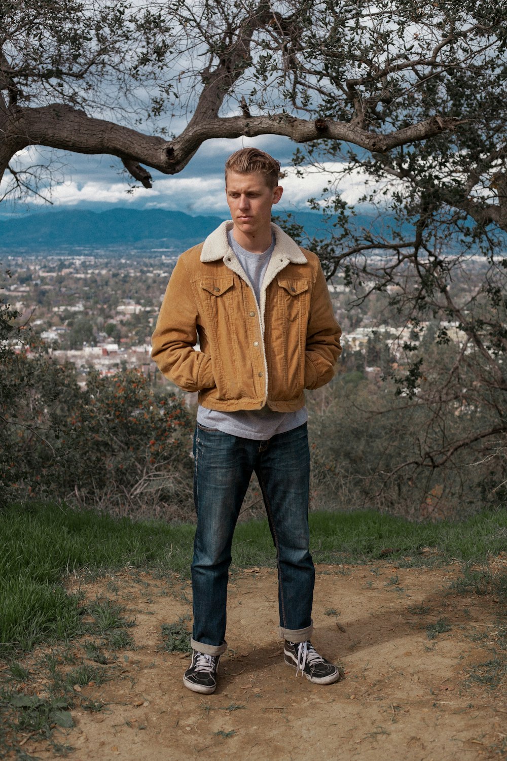 Foto hombre con chaqueta marrón parado cerca del árbol durante el día –  Imagen Vestir gratis en Unsplash