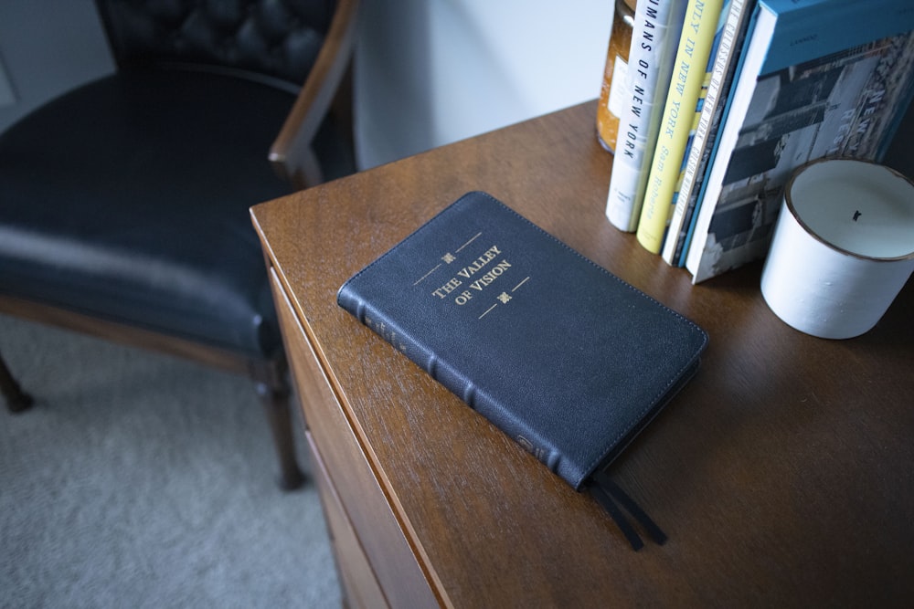 black leather book on brown wooden table