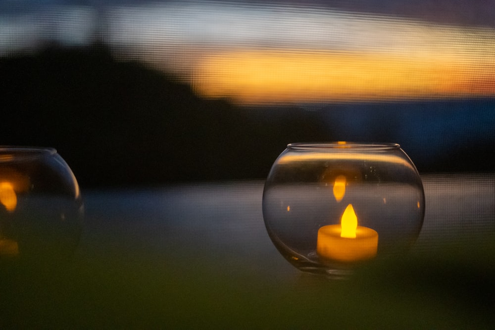 lighted candle in clear glass holder