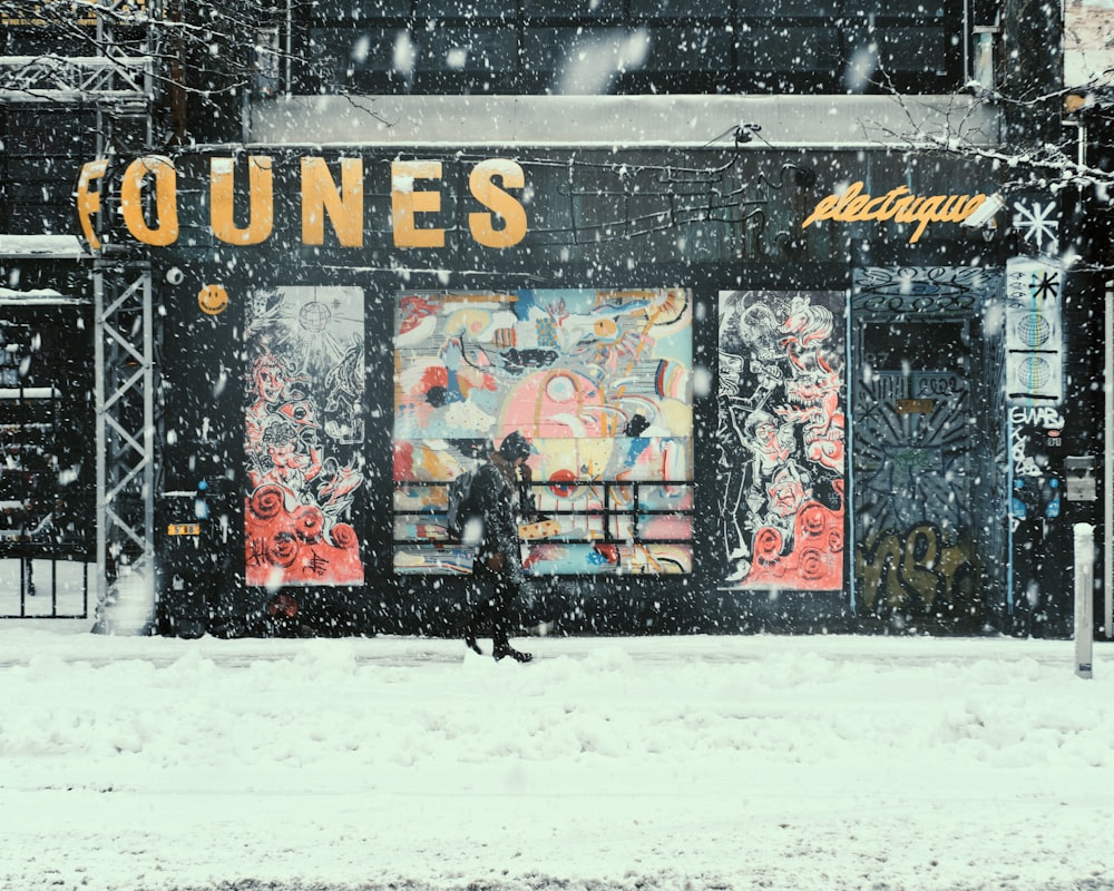 man in black jacket walking on snow covered ground during daytime