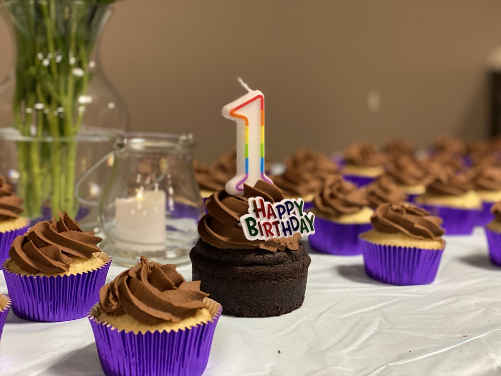 Schokoladen-Cupcake mit rosa und lila Kerzen