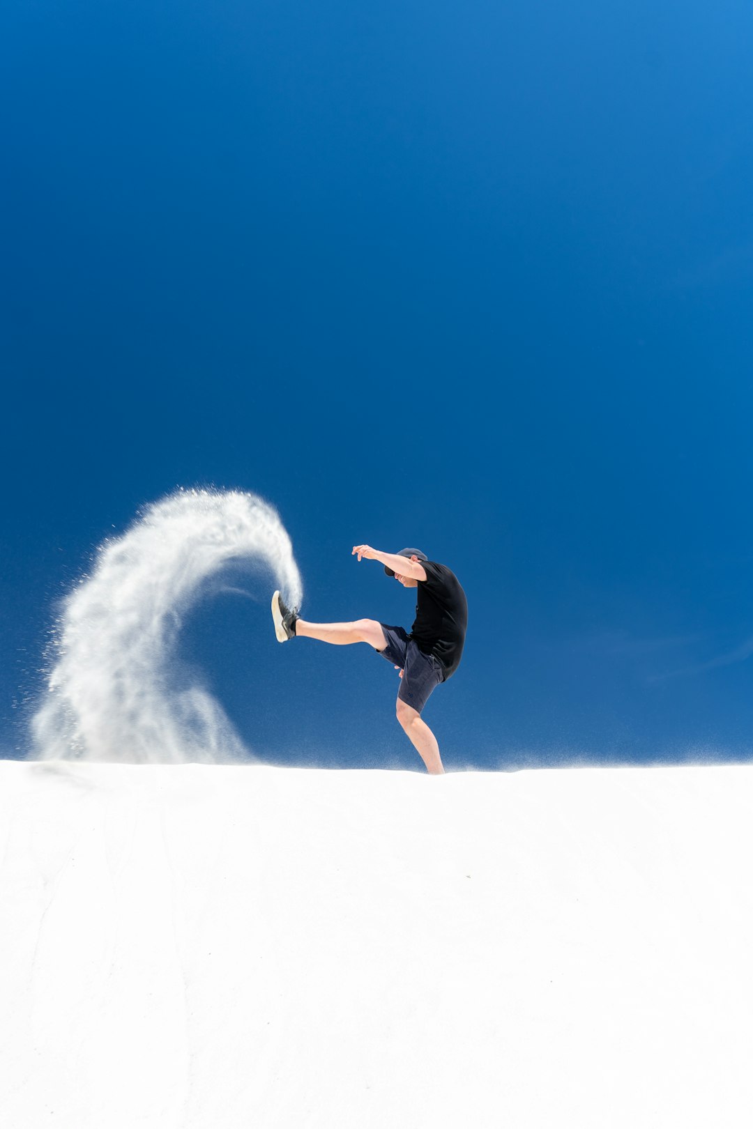 man in black shirt and black shorts surfing on white ocean wave during daytime