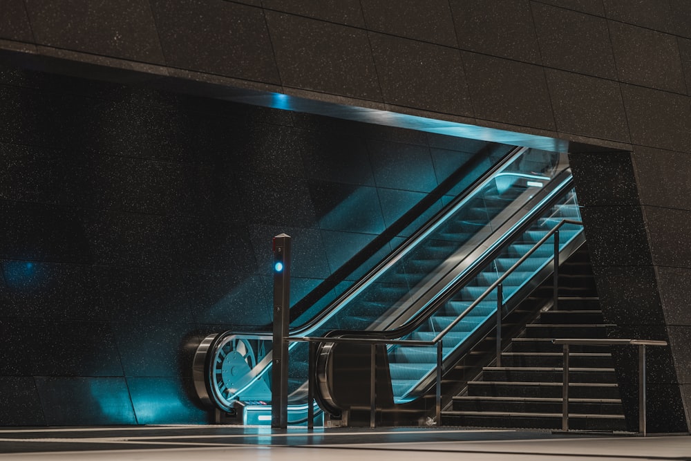 Escalera mecánica negra y azul en una habitación negra