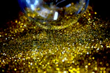 Close-up of a glittery pink and gold epoxy tumbler catching the light.