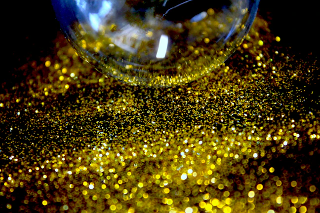 Close-up of a glittery pink and gold epoxy tumbler catching the light.