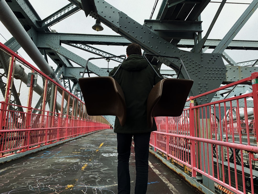 man in black pants standing on gray concrete floor