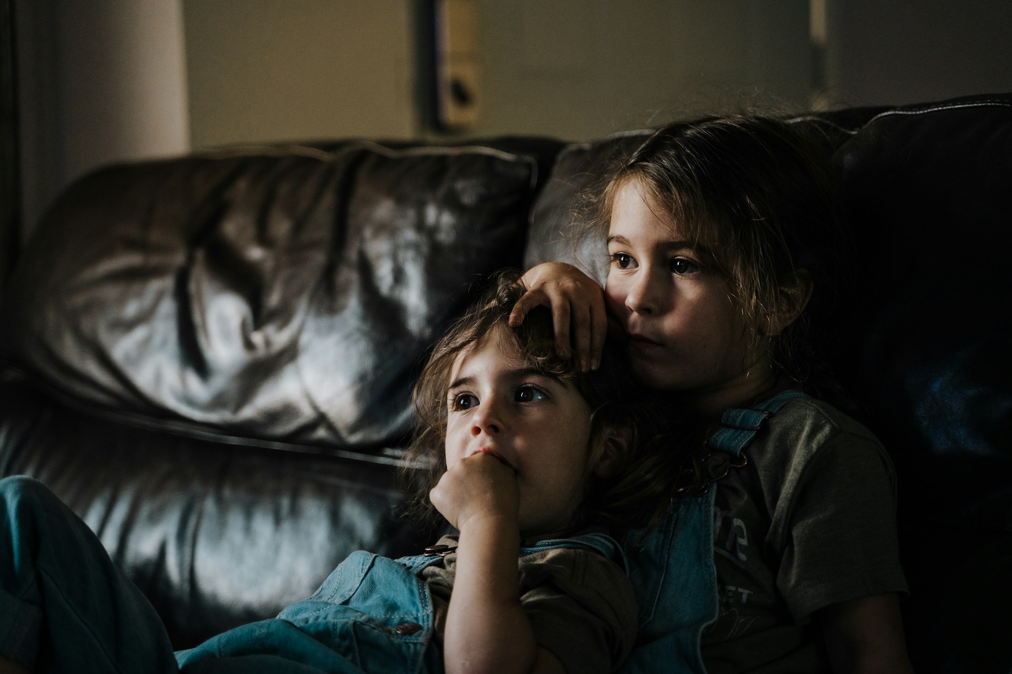 siblings laying on the sofa