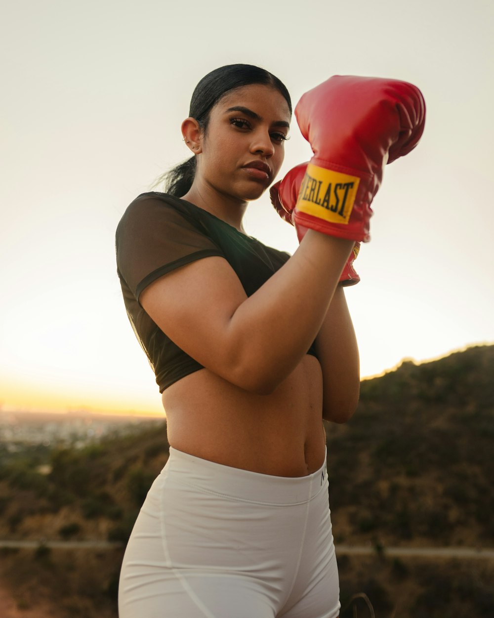 woman in black tank top and white shorts holding red and yellow bottle