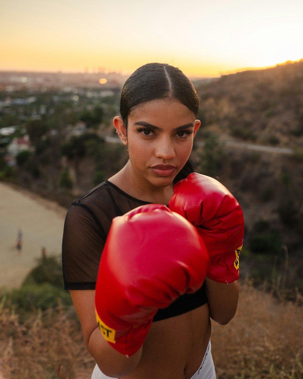 man in black t-shirt carrying red boxing gloves