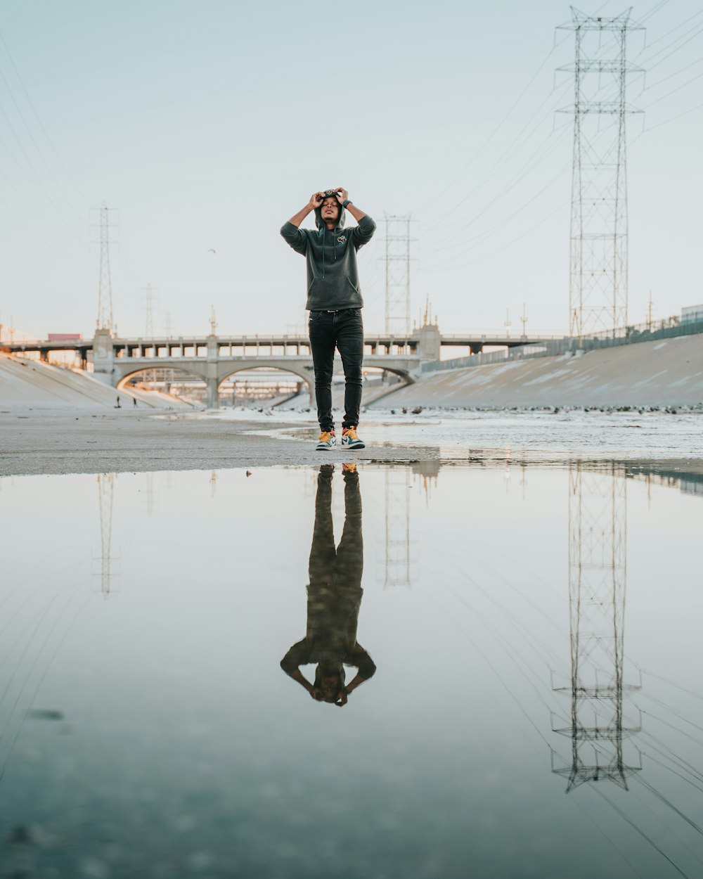 man in black jacket and black pants standing on water during daytime