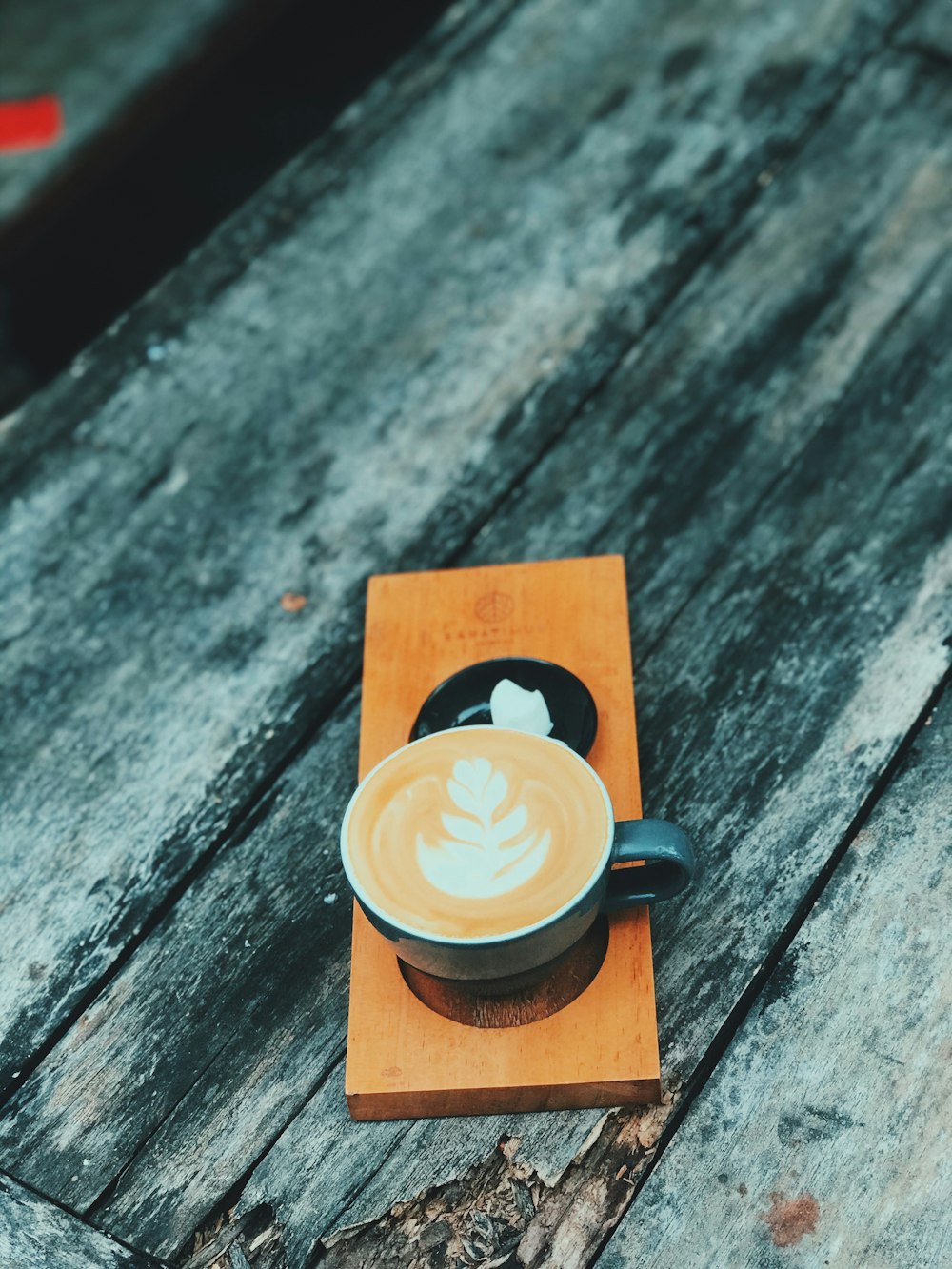 cappuccino in brown ceramic mug on gray wooden table