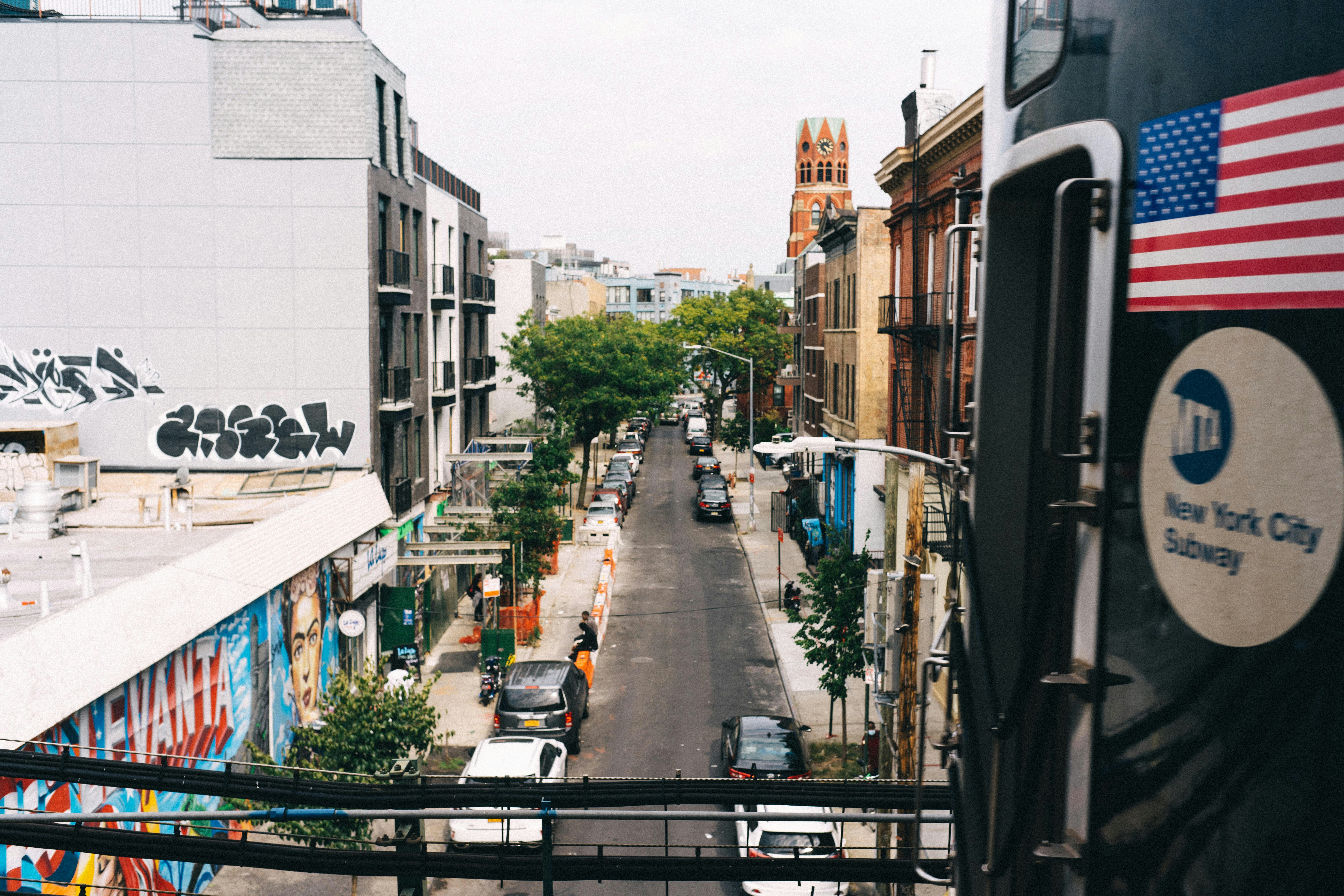 people walking on sidewalk near apartments in brooklyn during daytime
