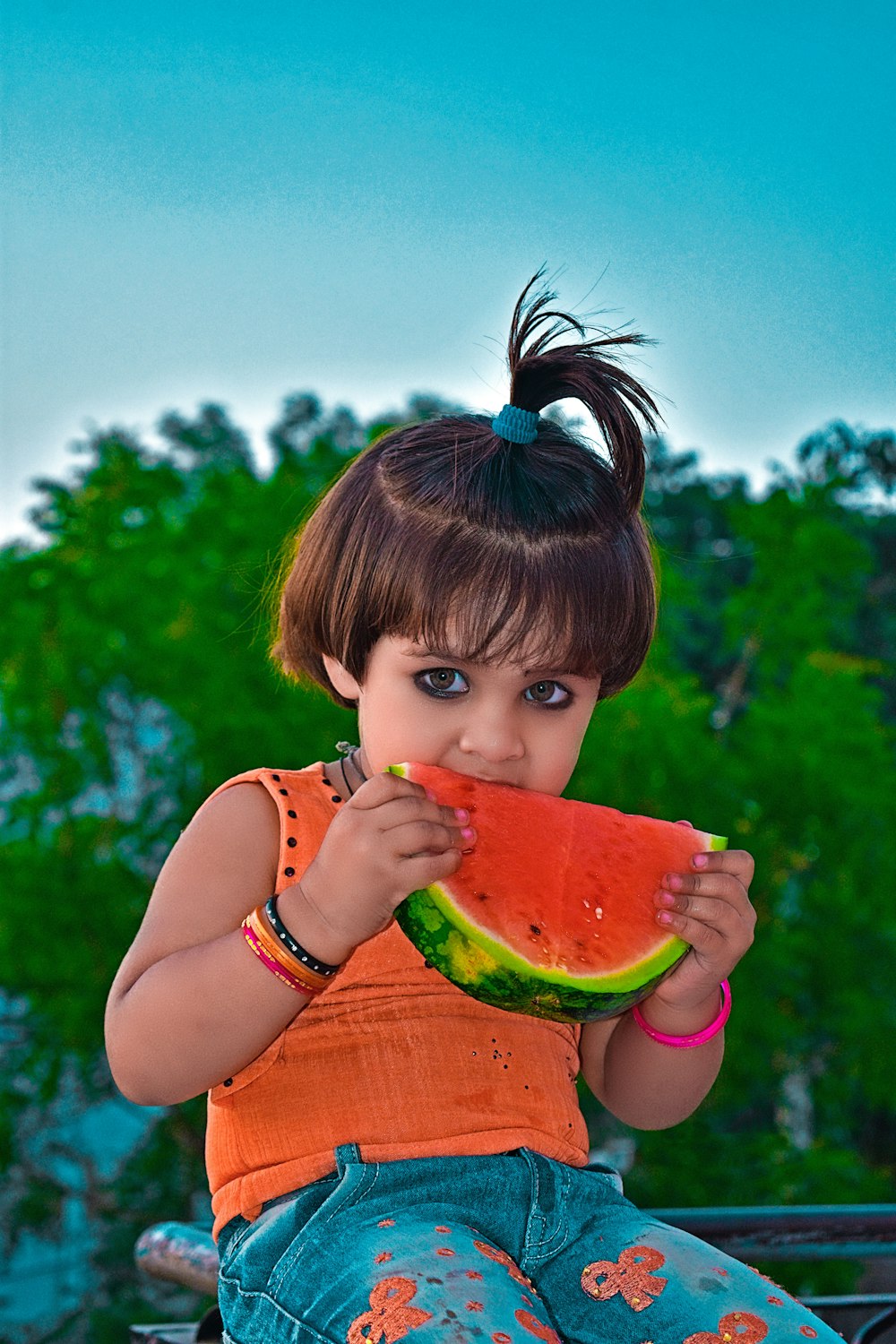 chica con camiseta sin mangas rosa comiendo sandía