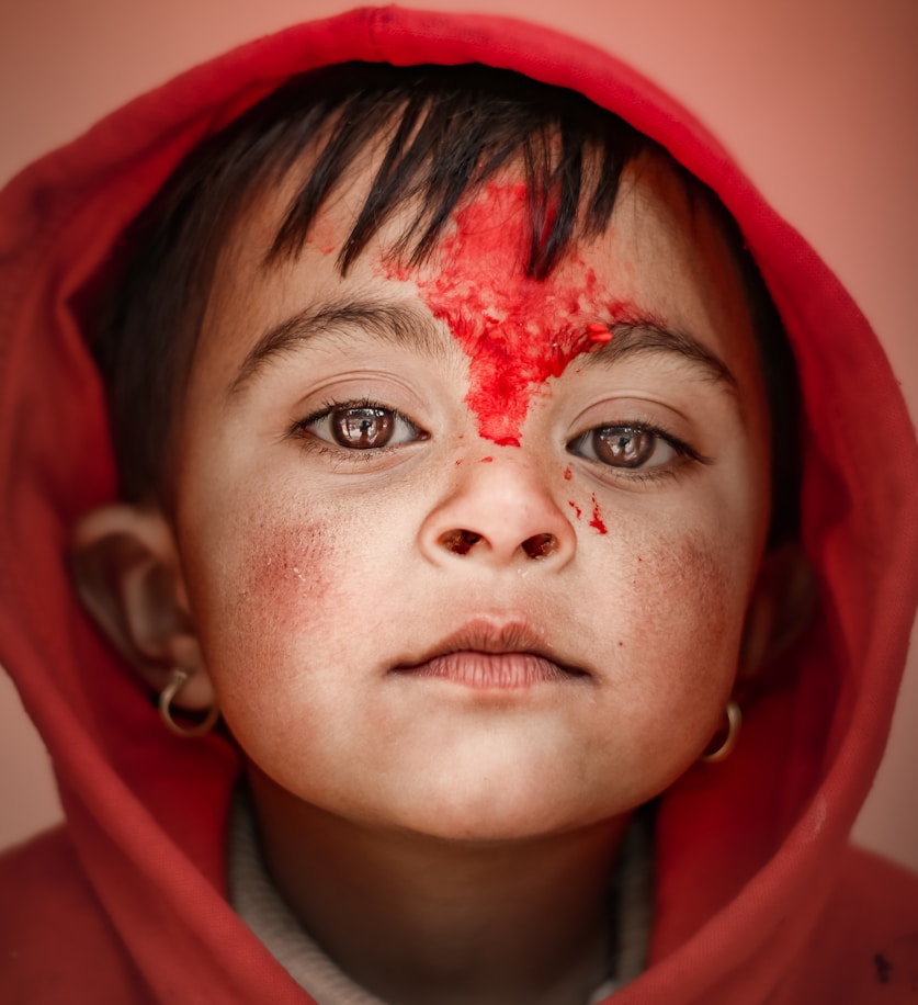 woman in red hoodie with red powder on face