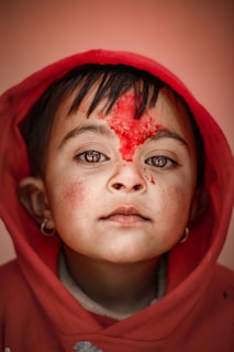 woman in red hoodie with red powder on face