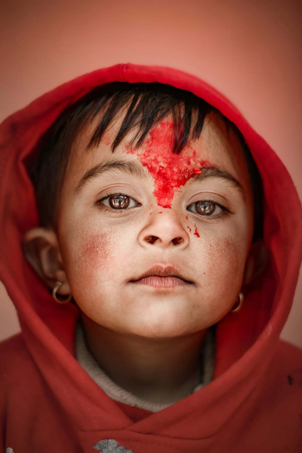 woman in red hoodie with red powder on face