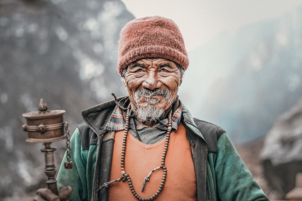 man in green jacket wearing brown knit cap