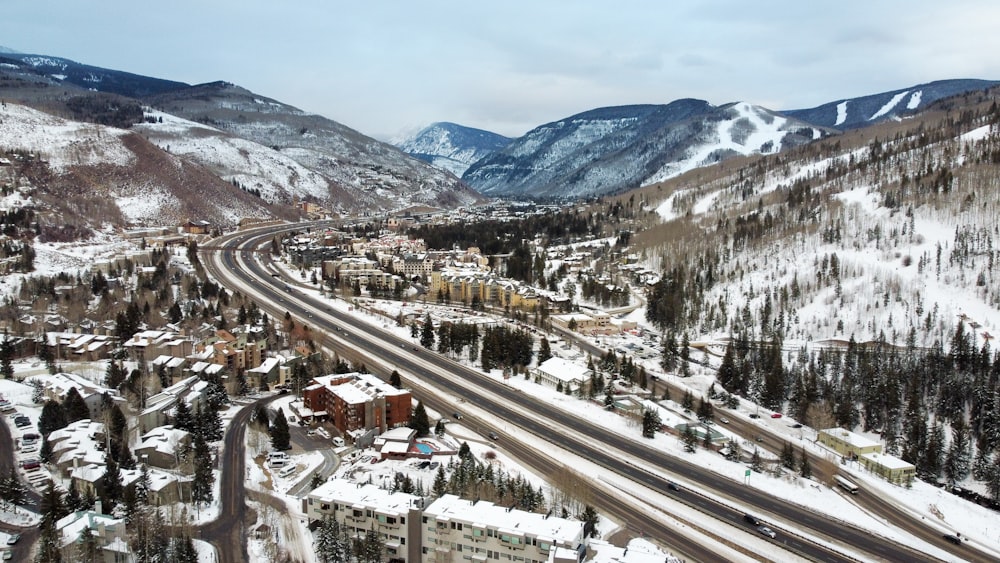 aerial view of city near snow covered mountains during daytime