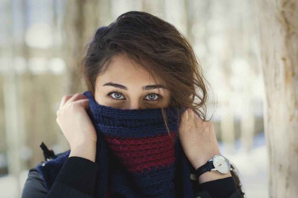 woman in black long sleeve shirt covering her face with red scarf