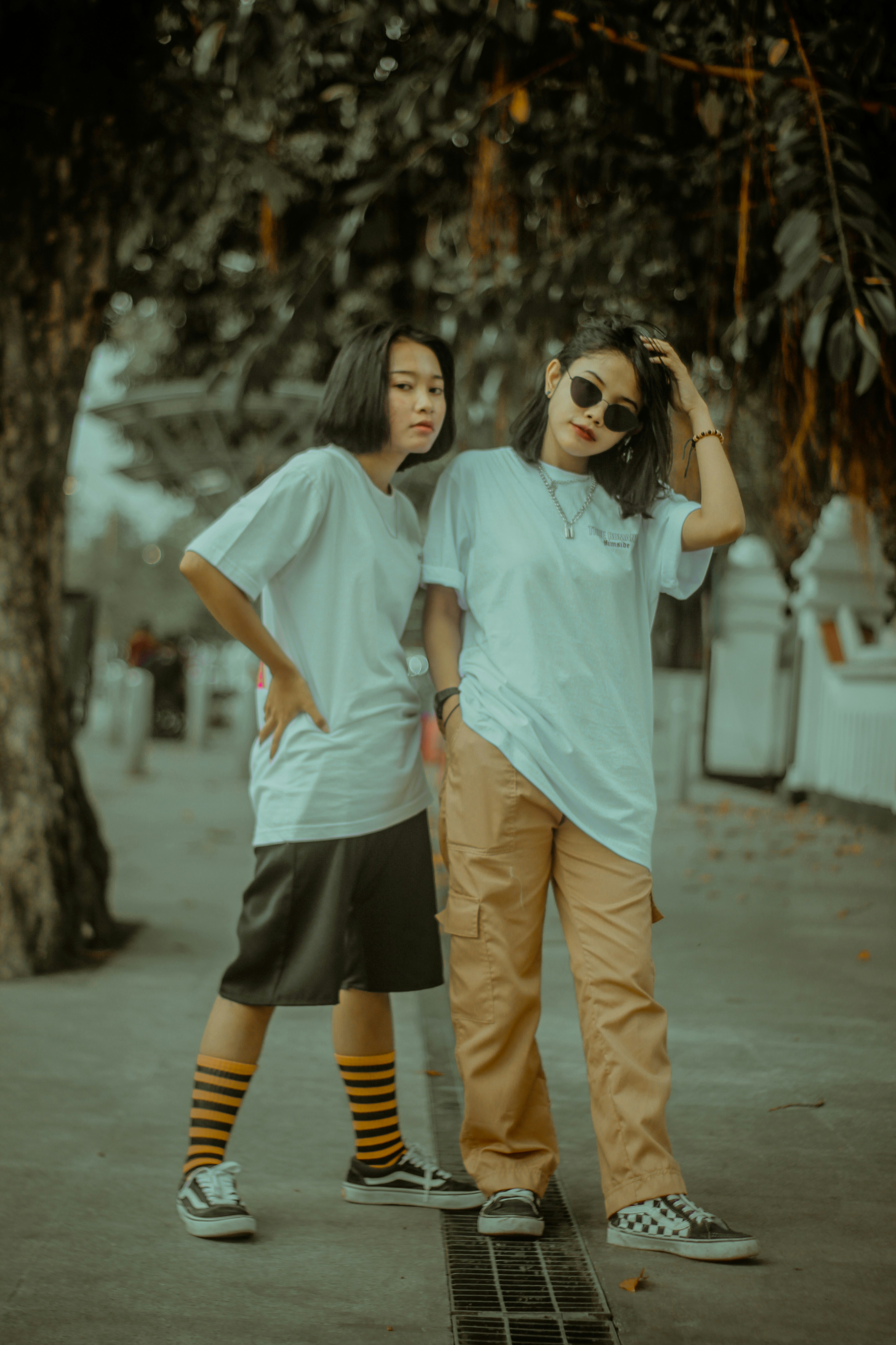 Wanita dengan kaos leher kru biru dan celana pendek coklat berdiri di jalan di siang hari