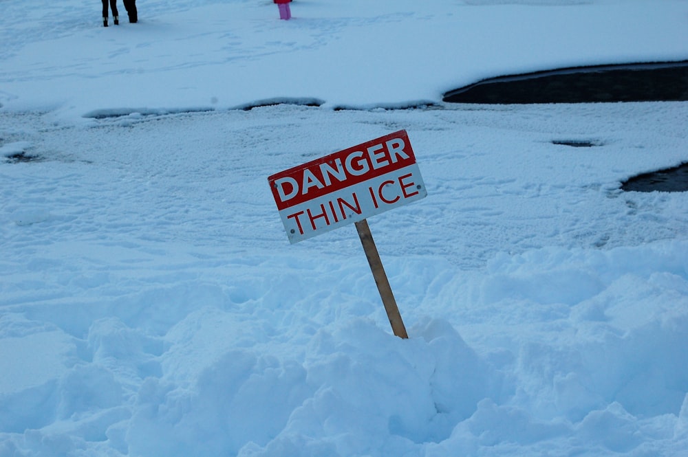 white and red open signage on snow covered ground