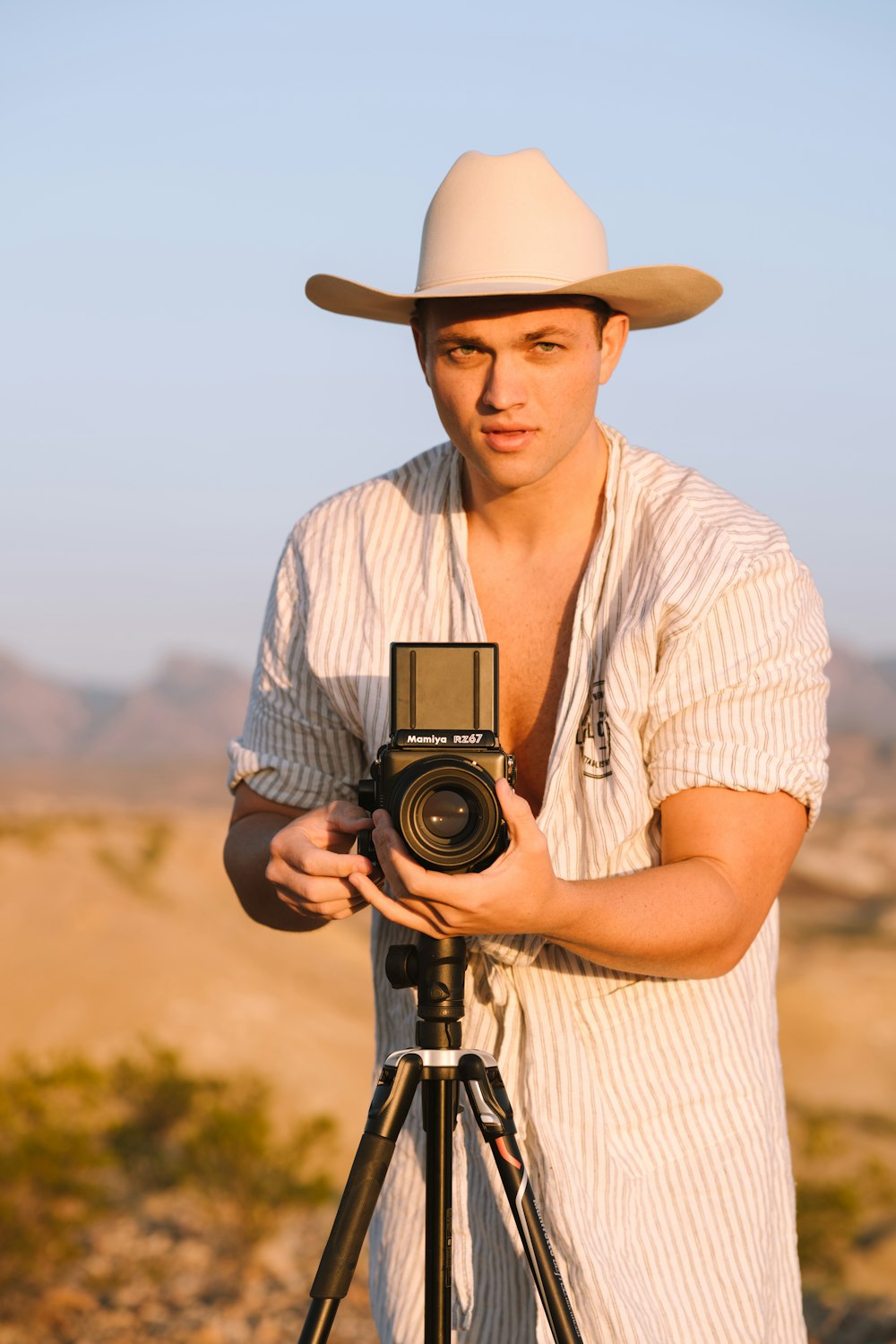 woman in white and black stripe shirt holding black camera