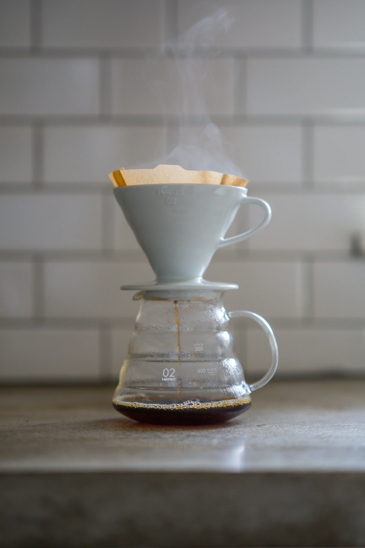 Pour-over coffee brewing with a white dripper and fresh coffee, no branded coffee bag shown