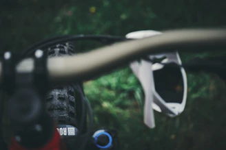 Close-up of a Verdevelo bike’s handlebar with a leafy trail in the background.