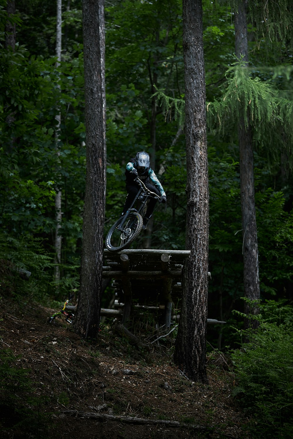 man in black jacket riding on black motorcycle in forest during daytime