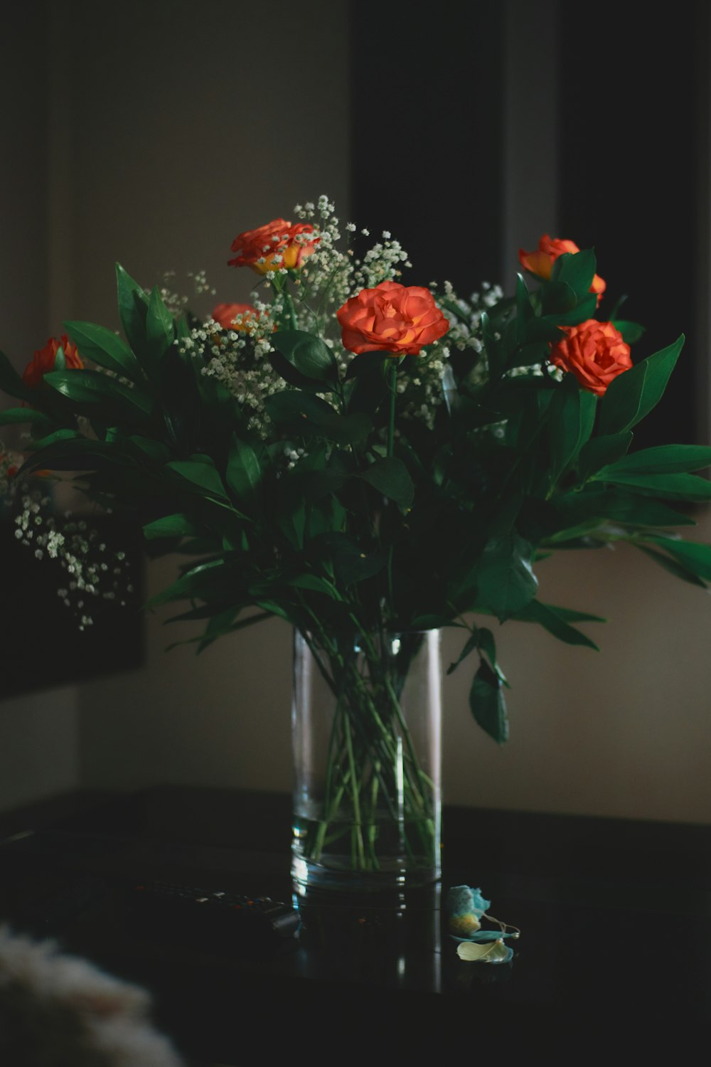 red and yellow flowers in clear glass vase