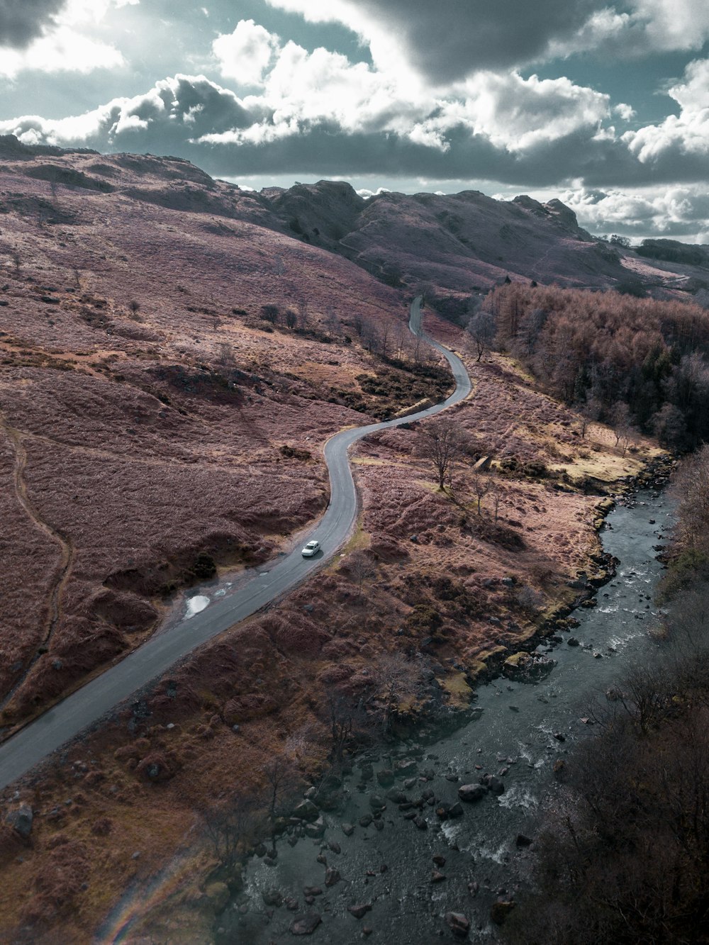 aerial view of road in the middle of brown mountains