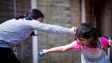 Participants enjoying a playful water balloon fight in the sun.