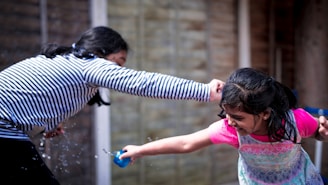 girl in pink shirt holding blue plastic toy