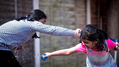 Participants enjoying a playful water balloon fight in the sun.