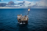 brown ship on sea under white clouds and blue sky during daytime