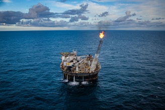 brown ship on sea under white clouds and blue sky during daytime