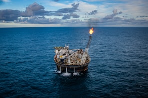 brown ship on sea under white clouds and blue sky during daytime