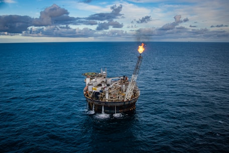 brown ship on sea under white clouds and blue sky during daytime