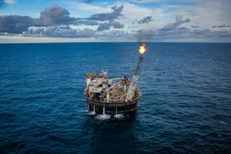 brown ship on sea under white clouds and blue sky during daytime