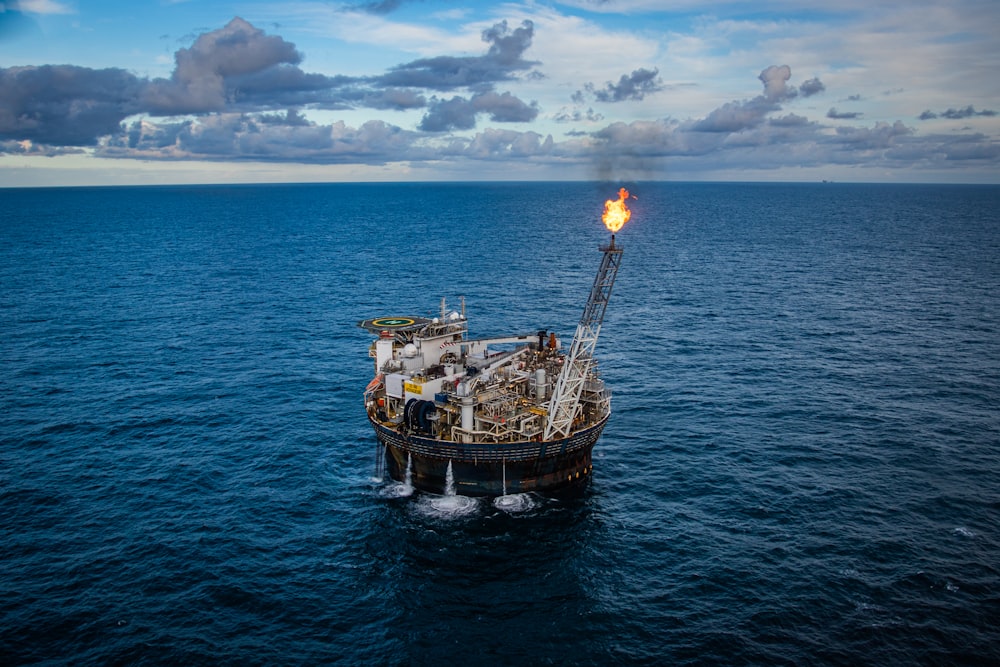 brown ship on sea under white clouds and blue sky during daytime