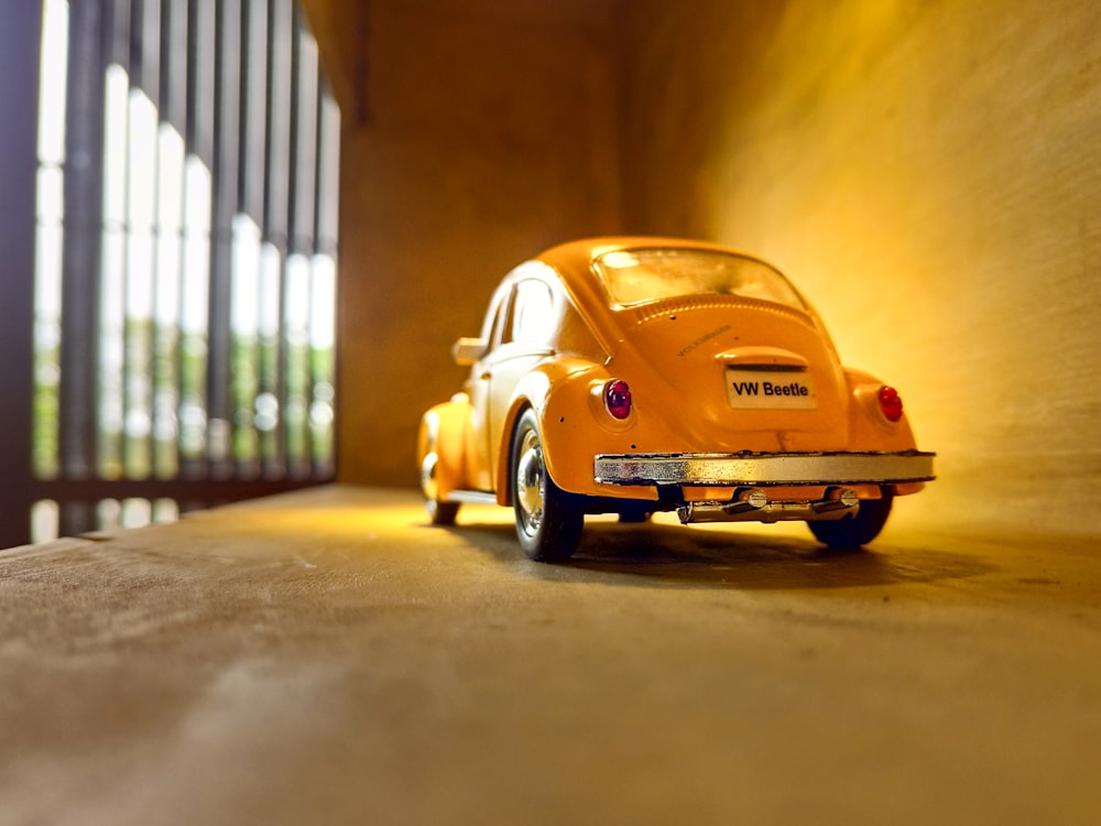 yellow volkswagen beetle parked beside white wall