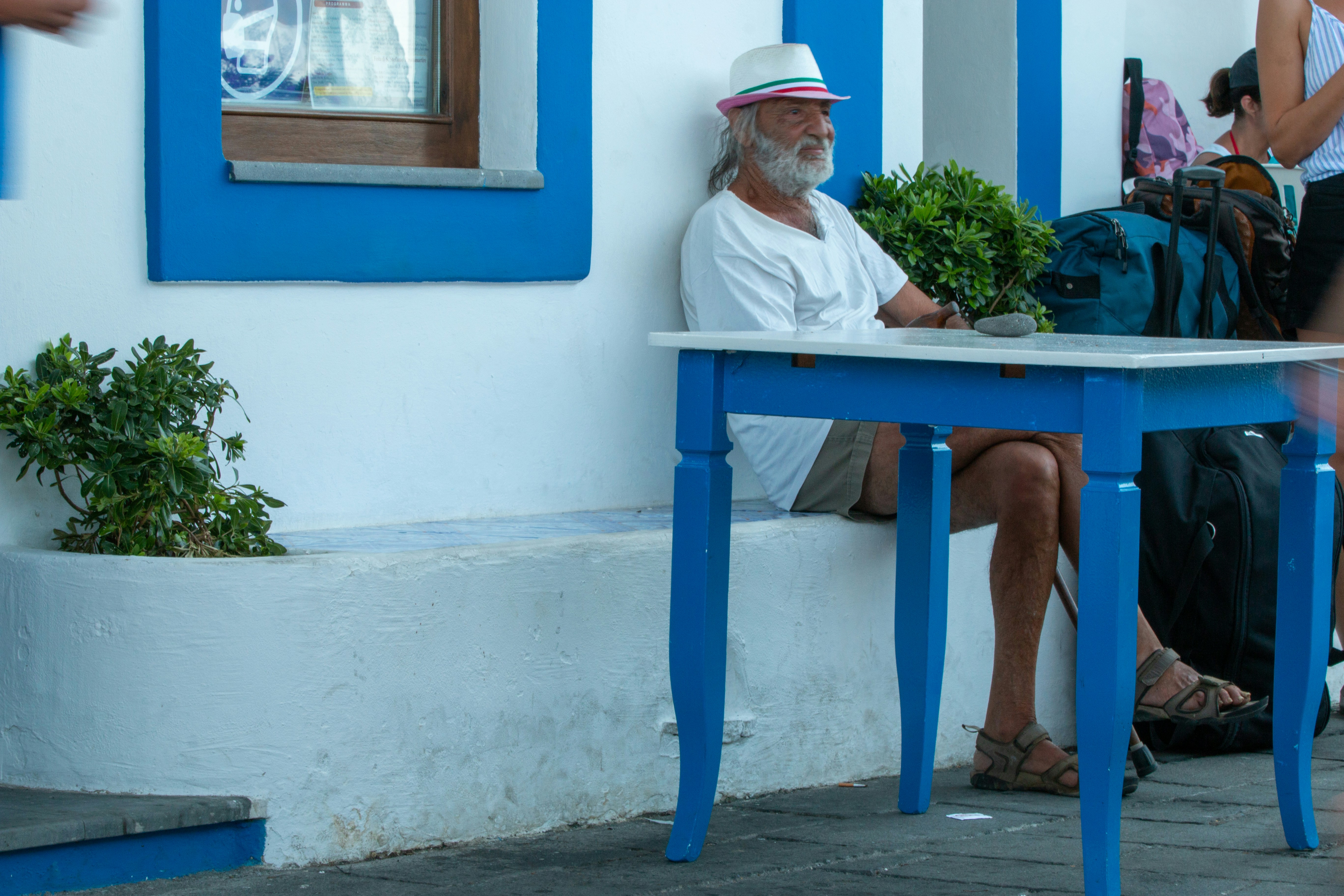 man in white button up shirt sitting on blue wooden bench