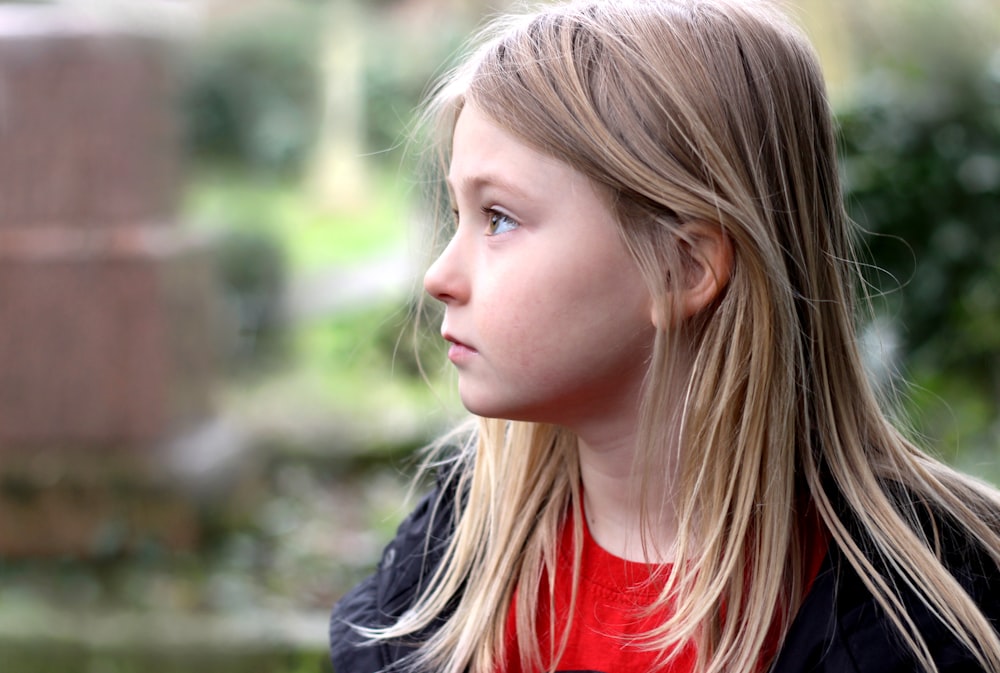 girl in red crew neck shirt and black jacket