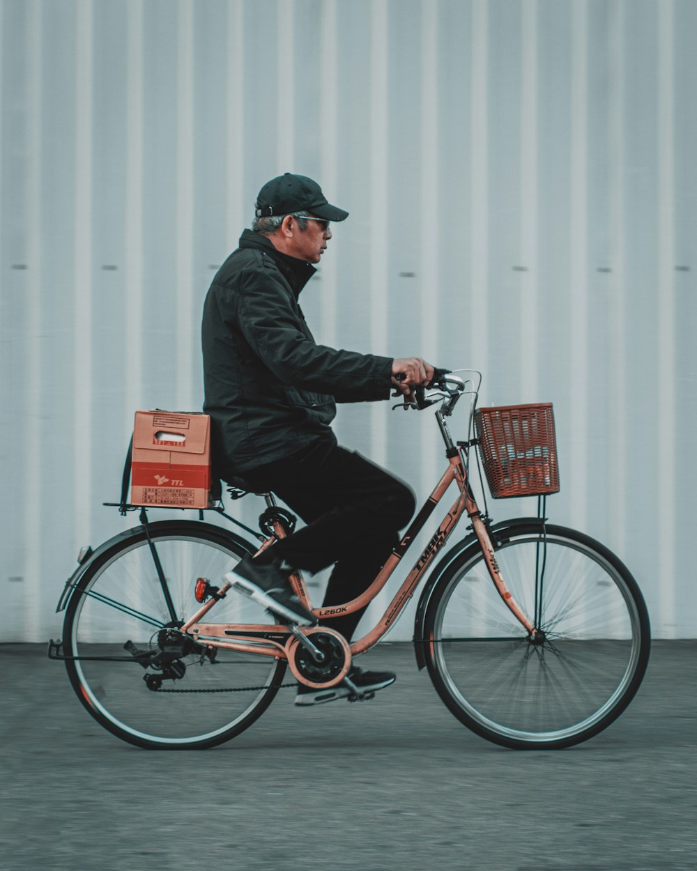 man in black jacket riding on red bicycle