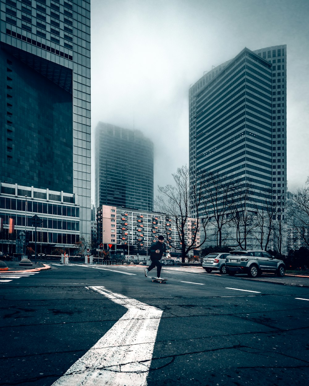 man in black jacket and pants walking on pedestrian lane during daytime