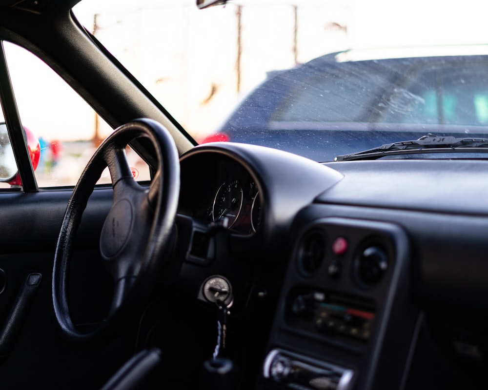 black car steering wheel during daytime